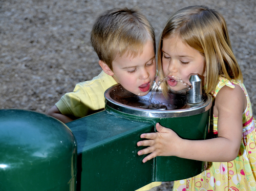 kid drinking water from fountain